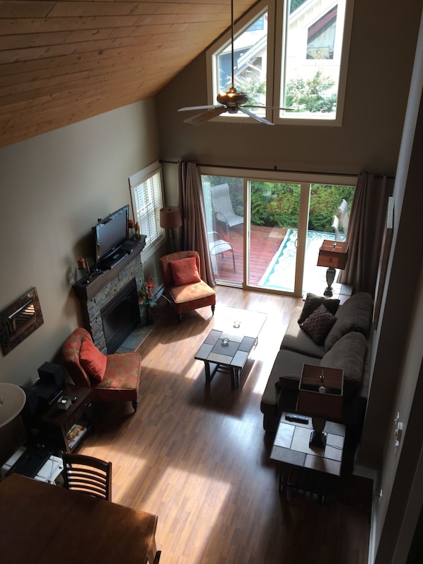 A spacious living room with a fireplace, a television, and a dining area.
