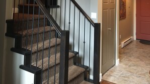 Una escalera de varios niveles con barandillas oscuras y peldaños alfombrados.
