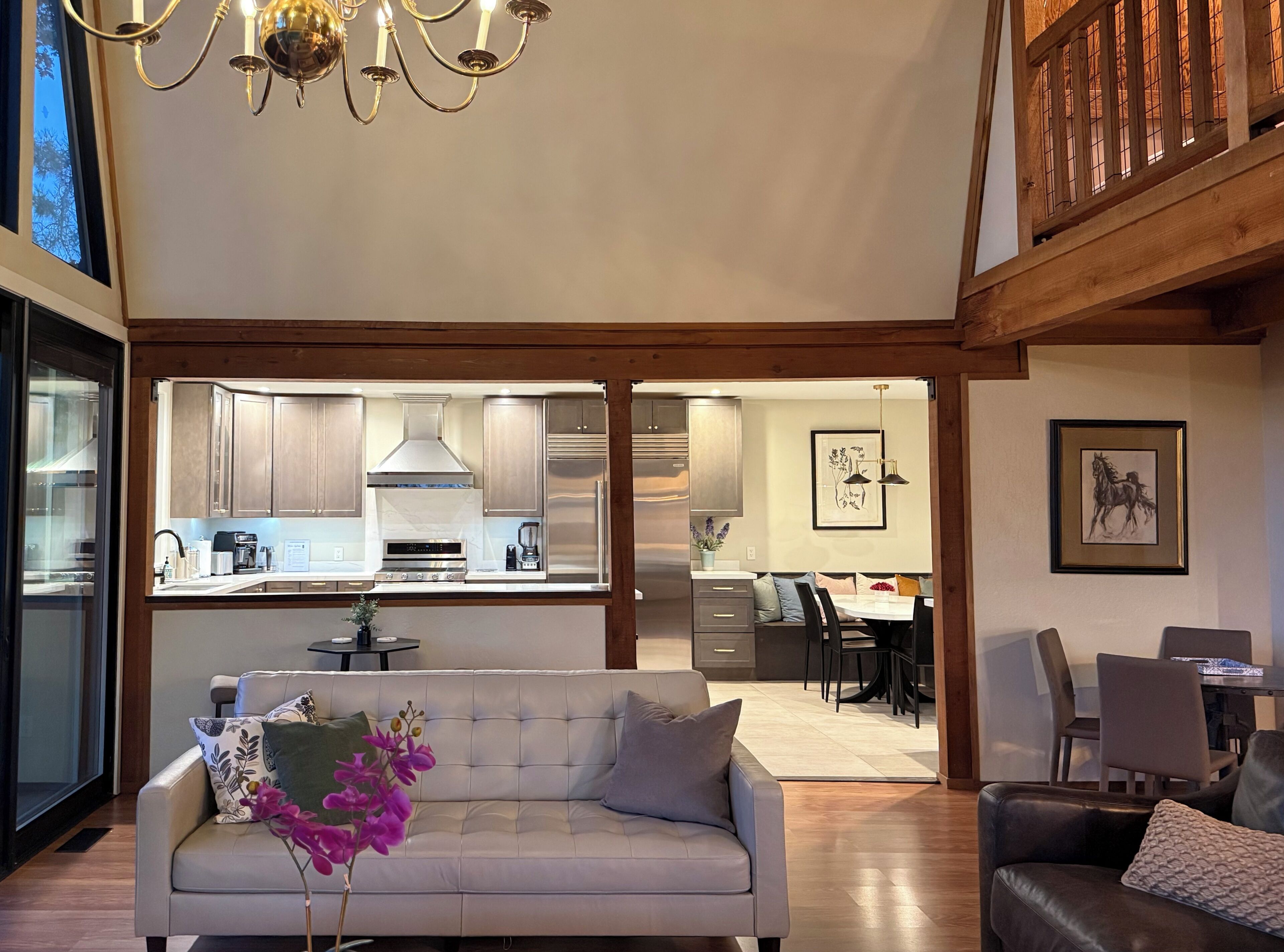 A modern interior with a sofa, dining area, kitchen, and staircase.