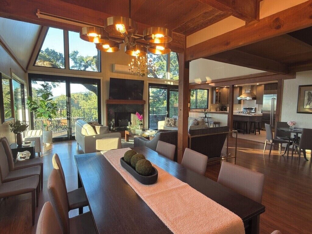 A spacious dining area with a long table, multiple chairs, and a fireplace.