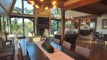 A spacious dining area with a long table, multiple chairs, and a fireplace.