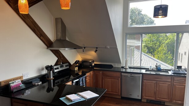 A modern kitchen with a large island, wooden cabinets, and pendant lighting. - Recently Renovated In-Town Bar Harbor 4 Bed 3 Bth Apartment with Private Parking (Bar Harbor)