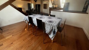 A dining area with a table covered in a patterned tablecloth, wooden chairs, and a ceiling fan. - Recently Renovated In-Town Bar Harbor 4 Bed 3 Bth Apartment with Private Parking (Bar Harbor)
