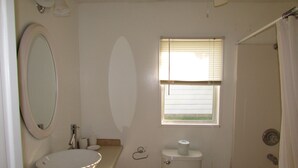 A bathroom with a bathtub, toilet, sink, and a window. - Come stay in our 2bd cabin on Table Rock Lake close to Silver Dollar City! (Branson)