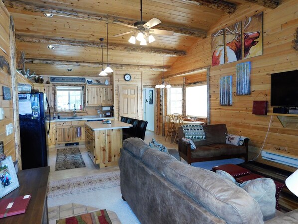 A cabin interior with a kitchen, dining area, and living room.
