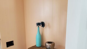 A corner with a wooden table, a turquoise vase, and a decorative bowl.