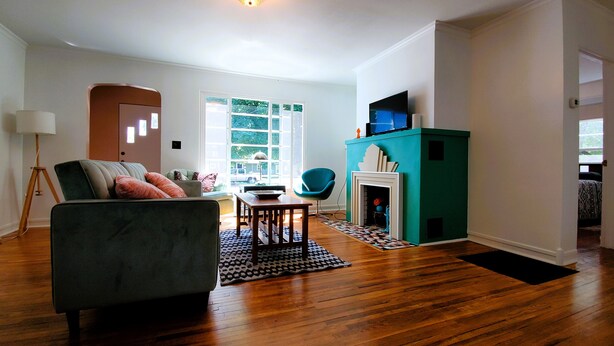 A living room with a sofa, a coffee table, a fireplace, and a television.