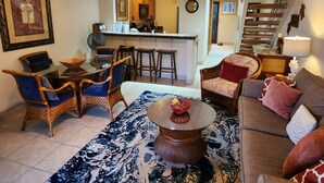 A spacious living room with a dining area, a kitchen in the background, and a staircase leading to an upper level. - BEAUTIFUL POIPU OCEAN VIEW 2 BRD 2.5 BATH Condo with A/C 
Great Fall Rates!
 (Koloa)