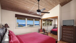 A bedroom with a large bed, a ceiling fan, a dresser, and a television. - BEAUTIFUL POIPU OCEAN VIEW 2 BRD 2.5 BATH Condo with A/C 
Great Fall Rates!
 (Koloa)
