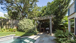 A backyard with a swimming pool, a pergola, and various plants. - Spacious, Updated Home, Ocean Views, Pool, Elevator, Walk to Beach & Restaurants (Isle of Palms)