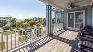 A covered balcony with a view of the ocean, a ceiling fan, and outdoor furniture. - Spacious, Updated Home, Ocean Views, Pool, Elevator, Walk to Beach & Restaurants (Isle of Palms)