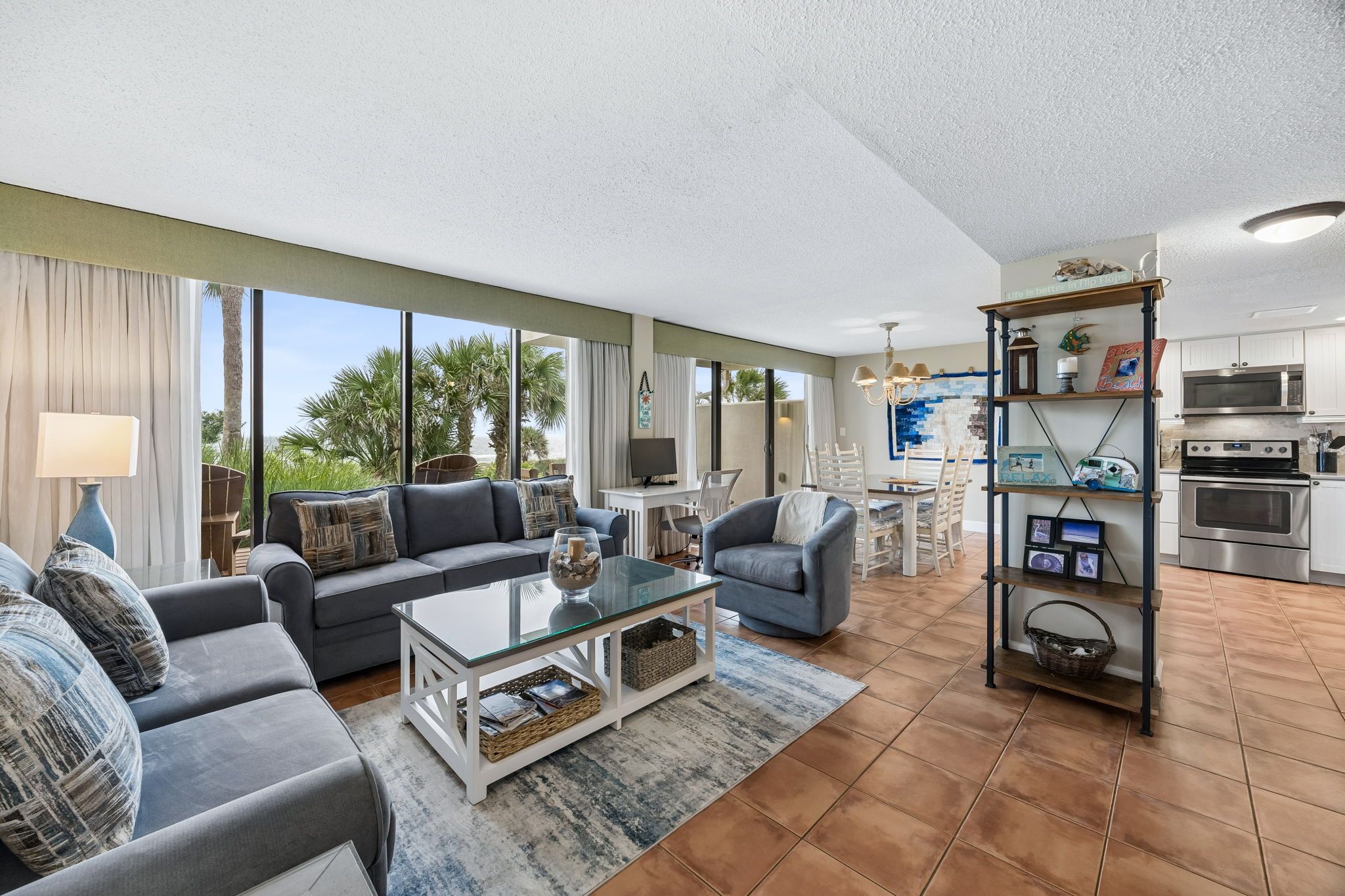 A spacious living room with a large window, a dining area, and a kitchen with modern appliances.