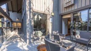 Eine Holzterrasse mit Sitzgelegenheiten und einem Feuerkorb.