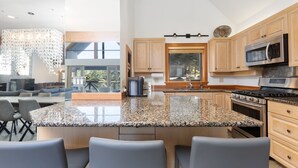 Eine moderne Küche mit Granit Arbeitsplatten, Holzschränken und Edelstahlgeräten.