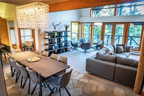 A spacious living area with a dining table, sofas, and a large chandelier. - Pinnacle Ridge 6 - Ski in Ski out, Private Hot Tub, Wood Fireplace (Whistler)