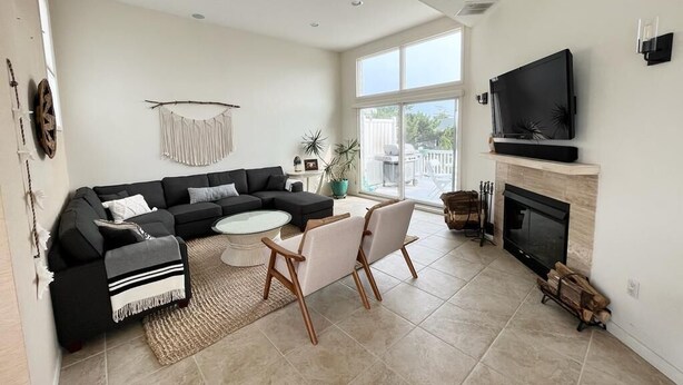 A modern living room with a sectional sofa, a coffee table, and a fireplace.