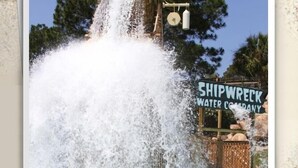 A water park with a large water slide and a sign that reads "Shipwreck Water Company".