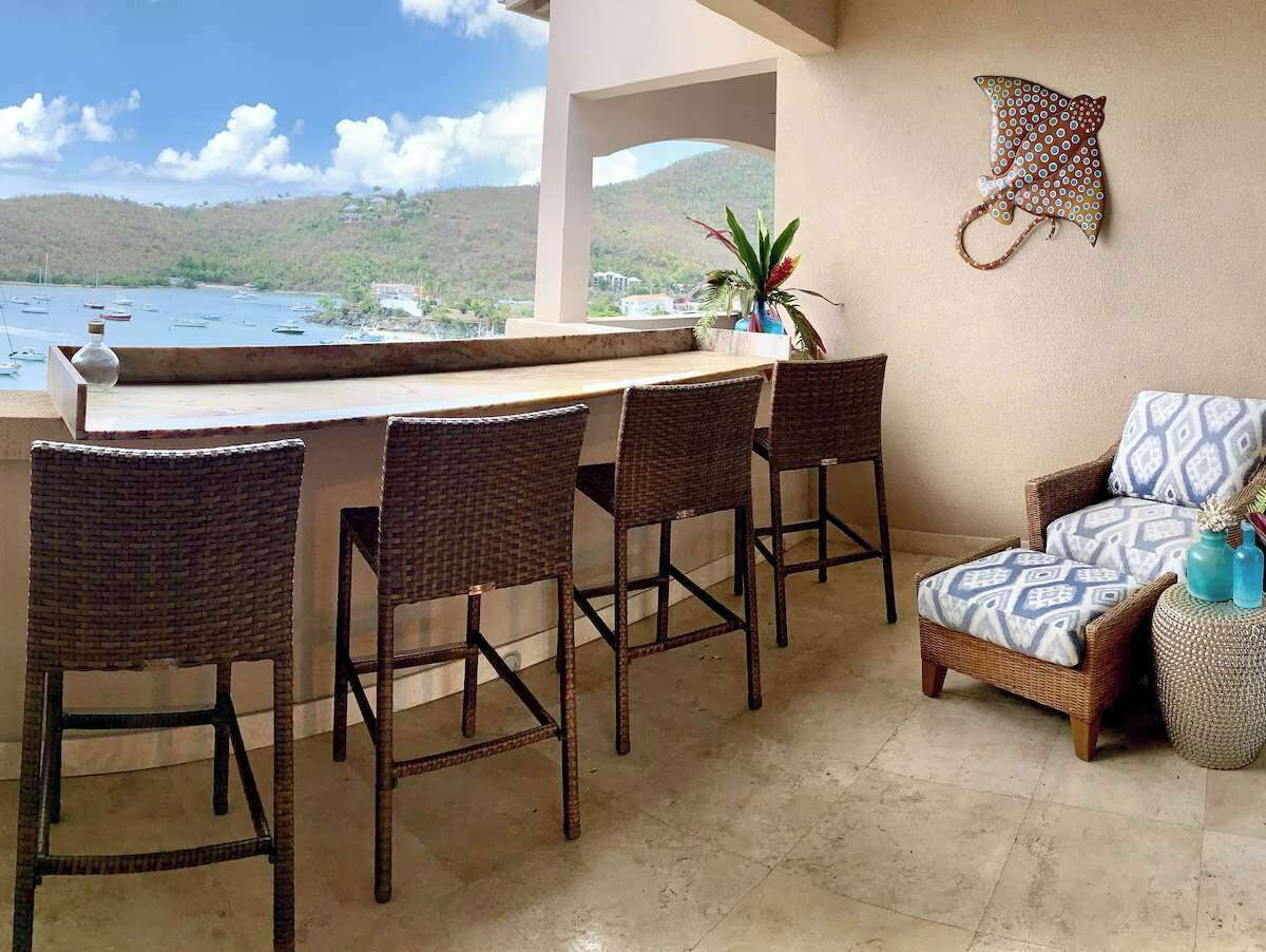 A bar area with wicker chairs and a view of the sea.