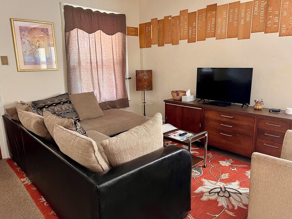 A living room with a sofa, television, and a wall with wooden plaques. - 10 min. Walk to the Falls (Niagara Falls)