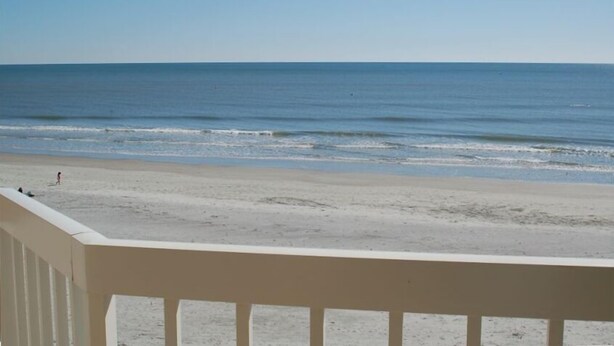 A beach view from a balcony with a railing. - Oceanfront Condo - Fantastic Views, Beautiful Furnishings!  (Folly Beach)