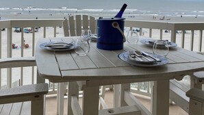 A beachside table with a blue bucket, empty plates, and cutlery. - Oceanfront Condo - Fantastic Views, Beautiful Furnishings!  (Folly Beach)