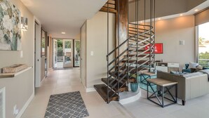 A modern interior with a spiral staircase, a kitchen area, and a living space with a view. - Renovated Mid-Century Mod Home with Spectacular Views in Point Loma (Spa & A/C) (San Diego)