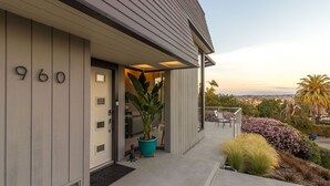 A modern house with the number 960 on the door, a covered porch with outdoor seating, and a view of the cityscape. - Renovated Mid-Century Mod Home with Spectacular Views in Point Loma (Spa & A/C) (San Diego)