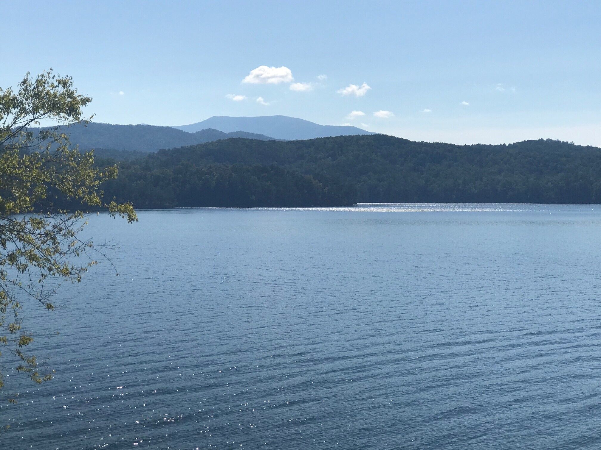 Un lago tranquilo con una cadena montañosa al fondo.