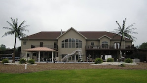 A large, two-story house with a covered porch and a balcony. - PICKLEBALL, Heated Pool, Game Room, Outdoor Oasis, Tennis, Basketball, & woods! (Griggsville)