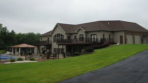 A large two-story house with a covered patio and a swimming pool. - PICKLEBALL, Heated Pool, Game Room, Outdoor Oasis, Tennis, Basketball, & woods! (Griggsville)