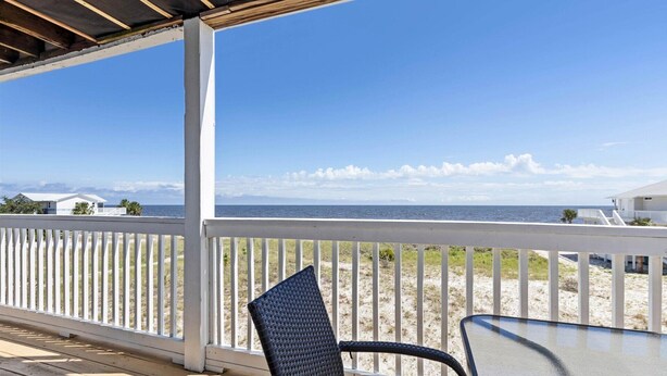 Eine überdachte Terrasse mit Blick auf Strand und Meer.