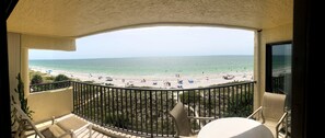 A balcony with a view of a beach, a railing, and a chair. - Magnificent Oceanfront Views And Spectacular Sunsets With Pool (Indian Rocks Beach)