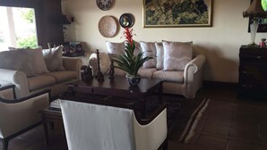 Una sala de estar con un sofá, una mesita de centro y una planta en maceta.