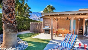 A backyard with a grill, a striped lounge chair, and a patio table. - Charming Family Friendly Home with Heated Pool.   (Palm Springs)