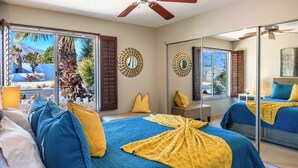 A bedroom with a large bed, a ceiling fan, and a view of the outdoors. - Charming Family Friendly Home with Heated Pool.   (Palm Springs)