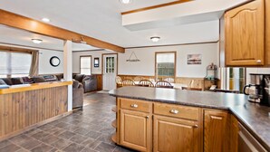 Una cocina amplia con armarios de madera, encimera de granito y comedor con mesa y sillas.