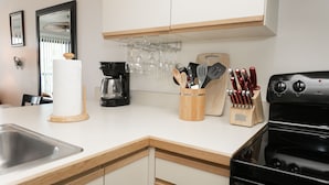 Une cuisine moderne équipée d’une machine à café, de verres à vin et d’un bloc à couteaux.