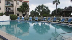 Une piscine avec des chaises longues et un panneau indiquant qu’il est interdit de plonger.