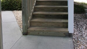 Eine Holztreppe mit Metallgeländer, das zu einer oberen Ebene führt.