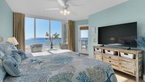 Ein Schlafzimmer mit einem großen Bett, einem Fernseher und Meerblick.