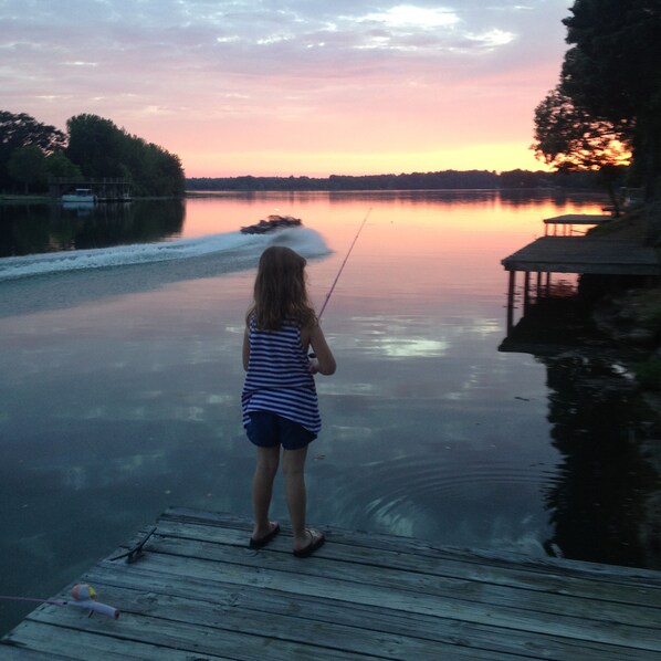 A person fishing on a wooden dock by a calm lake during sunset. - Wilson Lake,Private dock RTJ Golf Close by Last min Discount for the Holiday’s (Town Creek)