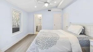 Un dormitorio con cama, ventana y puerta.