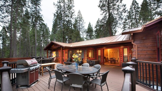 A wooden deck with a dining area, barbecue grill, and outdoor seating. - Buss Stop (Wawona)