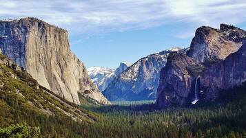 A mountainous landscape with a prominent rock formation and a waterfall.