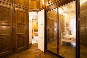 A room with wooden paneling, a bed with a patterned bedspread, and a white radiator. - Amazing apartment with 2 bedrooms with ensuite bathrooms - WIFI/Elevator (Roma)