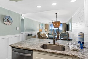 Enjoy meals in the kitchen with a granite countertop, stainless steel sink, and dishwasher, and dine at the table set for two.