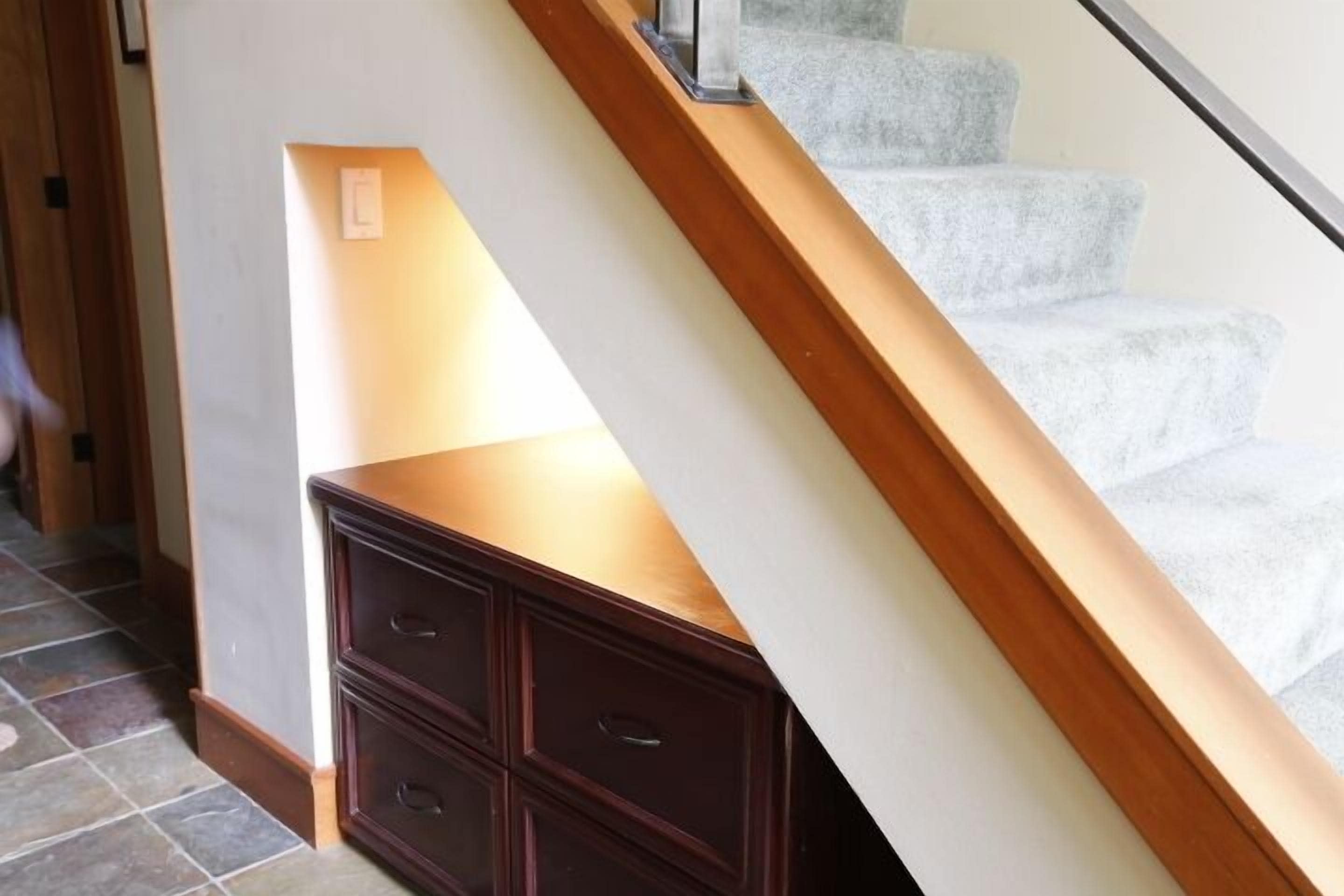 A staircase with a wooden handrail and a light-colored carpet.