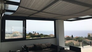 A modern living room with a large window overlooking a coastal view.