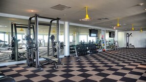 A gym with various exercise equipment, a checkered floor, and yellow pendant lights. - GREAT GALVESTON GETAWAY! STRESS-FREE BEACH VACATION! (Galveston)