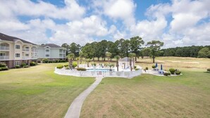 A golf course with a clubhouse, a swimming pool, and a walking path. - 5 minutes to the beach! Cozy 2 King BR 2BA Condo at Myrtlewood Golf Club (Myrtle Beach)